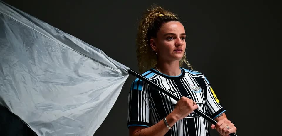 Jugadora de Newcastle sosteniendo una bandera en estudio