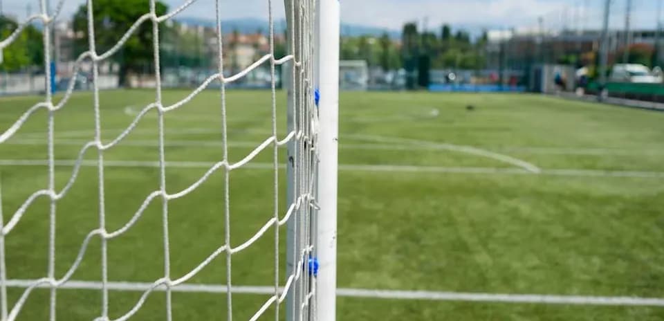 Red de gol en campo de fútbol con césped artificial