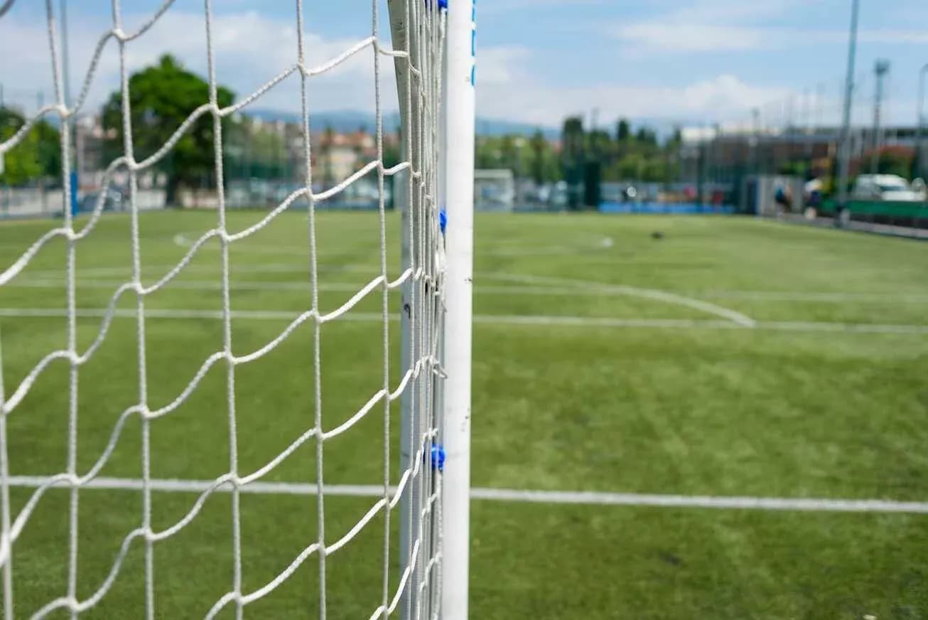 Red de gol en campo de fútbol con césped artificial