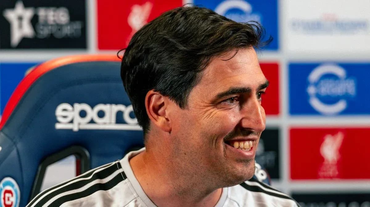 Entrenador sonriendo en conferencia de prensa