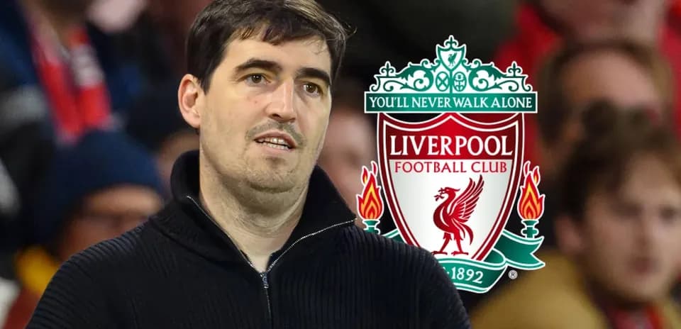 Hombre en el estadio con logo de Liverpool detrás