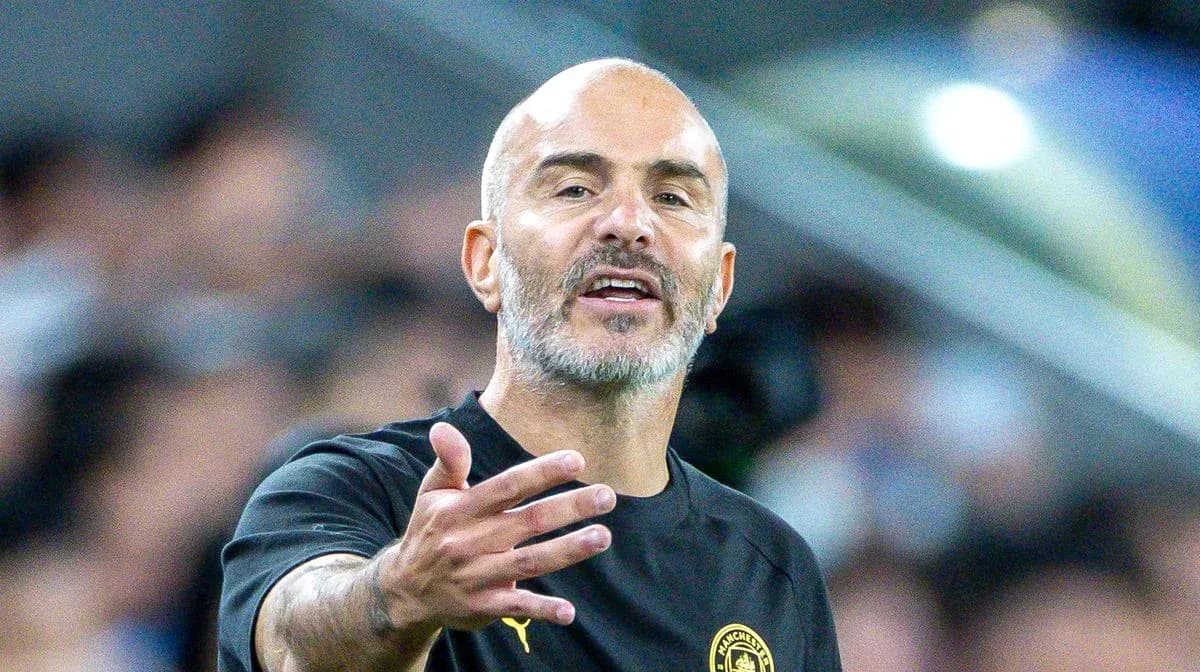 Entrenador gesticulando durante un partido de fútbol
