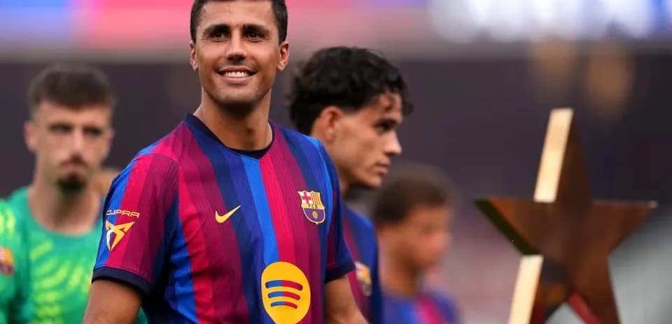 Jugador de Barcelona sonriendo con trofeo en mano
