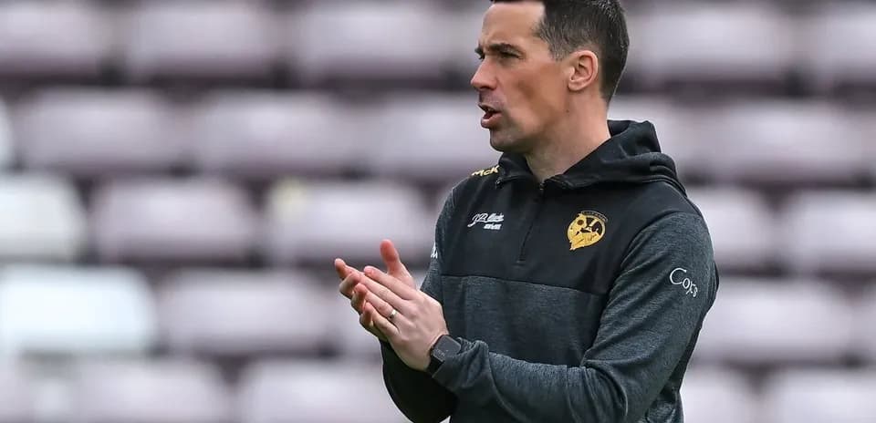 Entrenador aplaudiendo en el banquillo del estadio