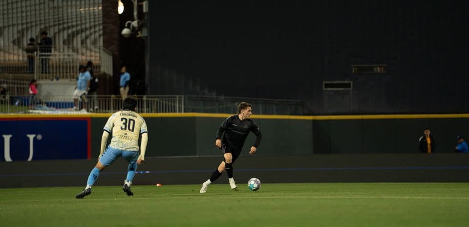 Jugador con balón durante el partido de fútbol