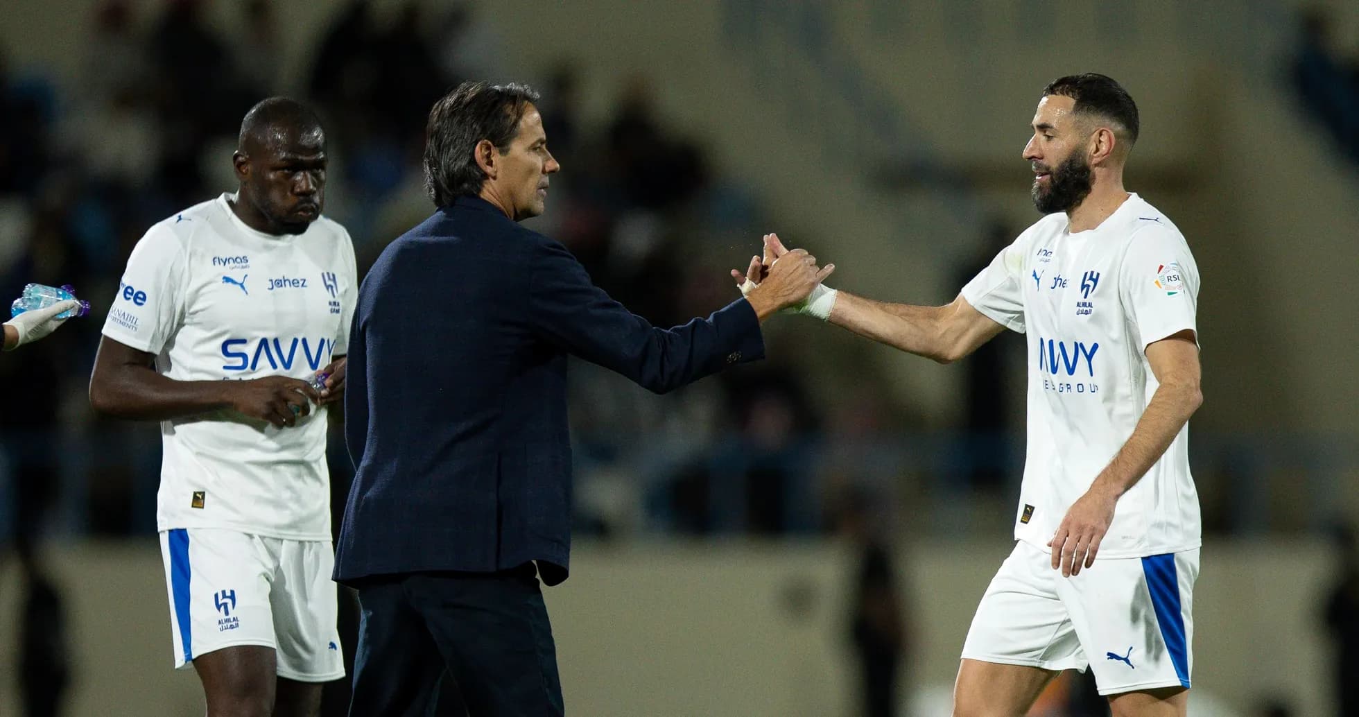 Entrenador saludando a jugador durante sustitución