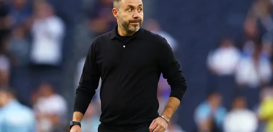 Entrenador caminando por el campo durante el partido