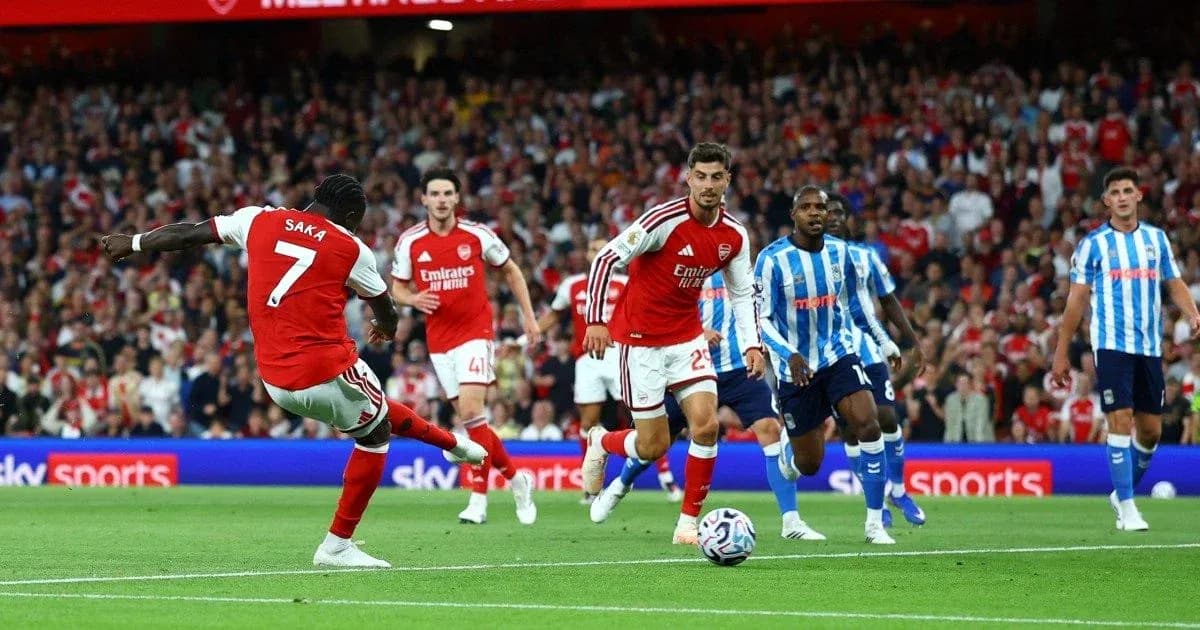 Saka disparando durante un partido de Arsenal