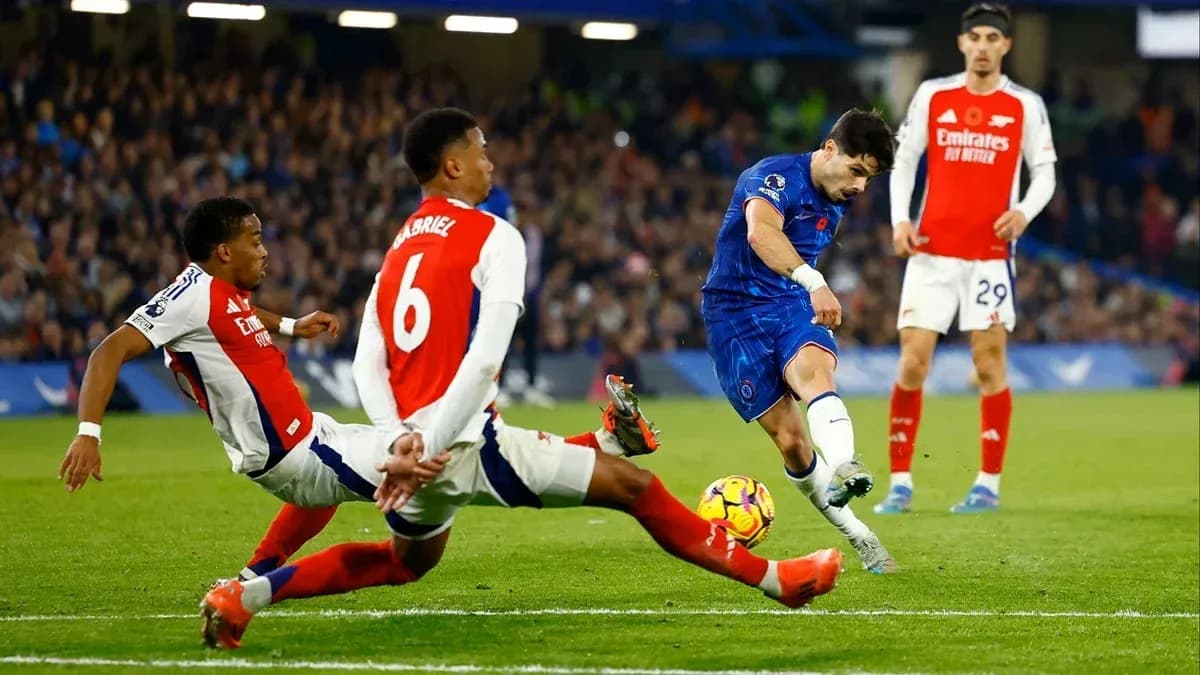 Jugador de Chelsea disparando mientras es tackleado