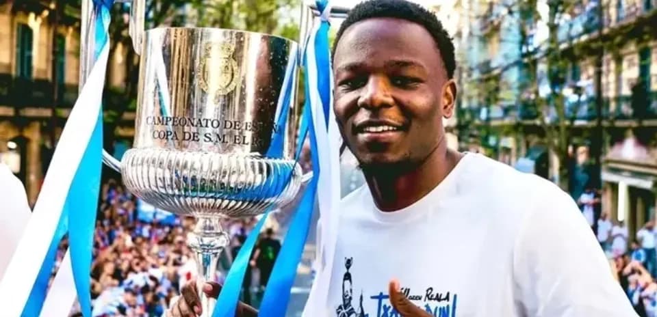 Jugador sosteniendo trofeo en celebración callejera