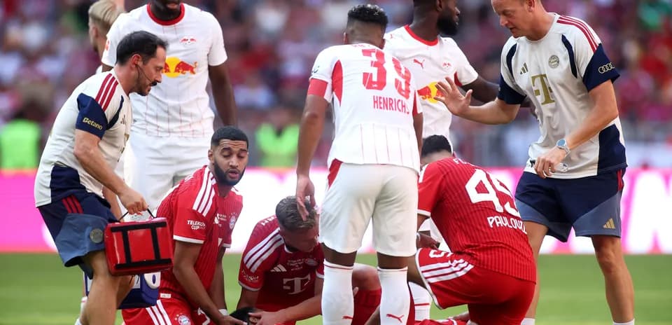 Jugadores de Bayern Munich atendiendo a compañero lesionado