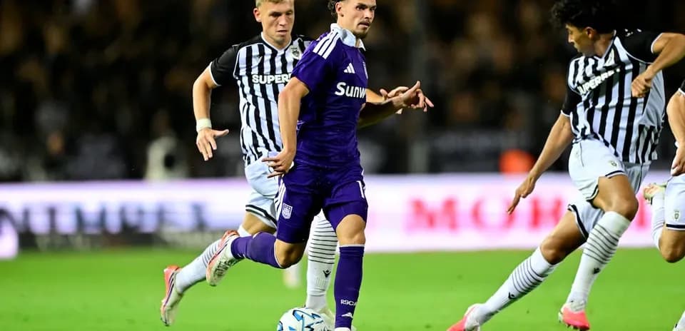 Jugador de Anderlecht esquivando a defensores de PAOK