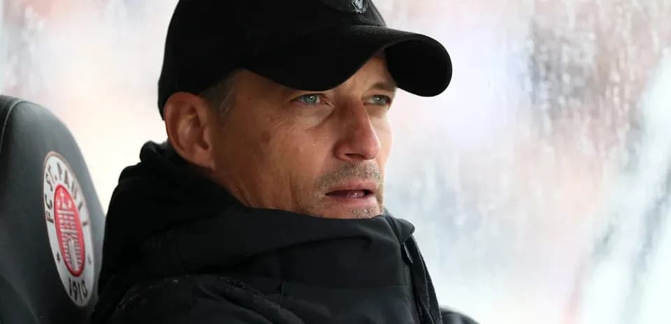 Entrenador en el banquillo durante un partido lluvioso