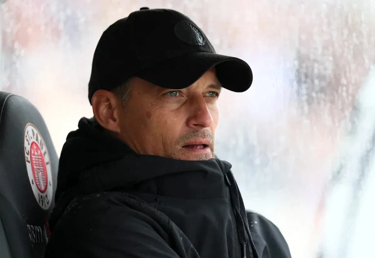 Entrenador en el banquillo durante un partido lluvioso