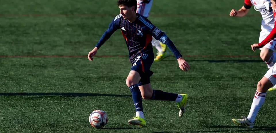 Jugador corriendo con el balón en el campo