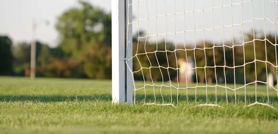 Portería de fútbol en campo verde iluminado