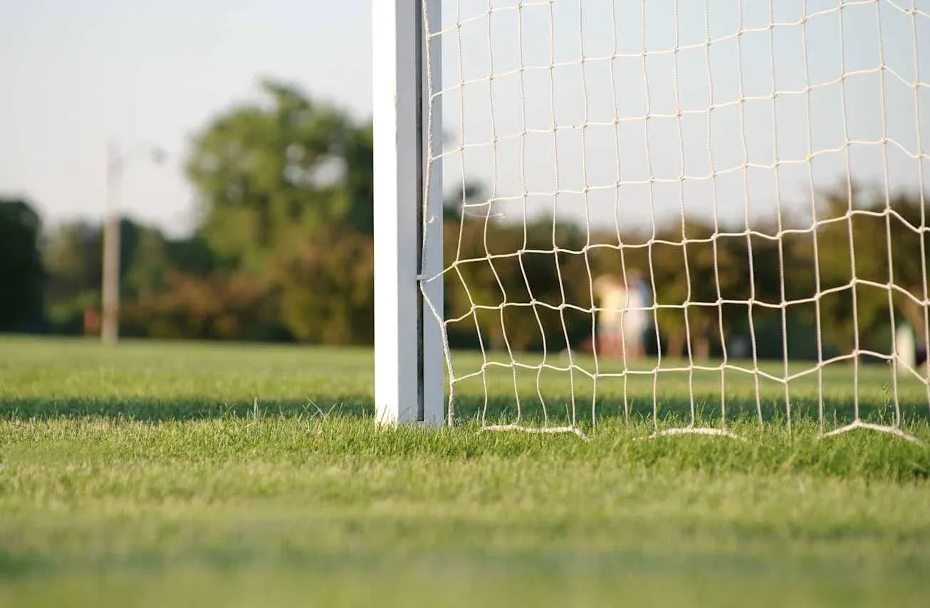 Portería de fútbol en campo verde iluminado