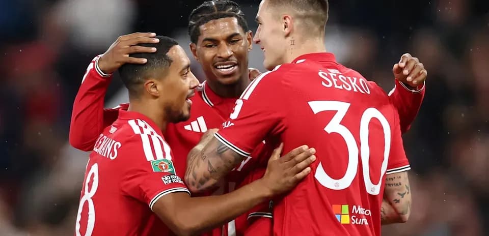 Jugadores celebrando en uniforme rojo tras gol