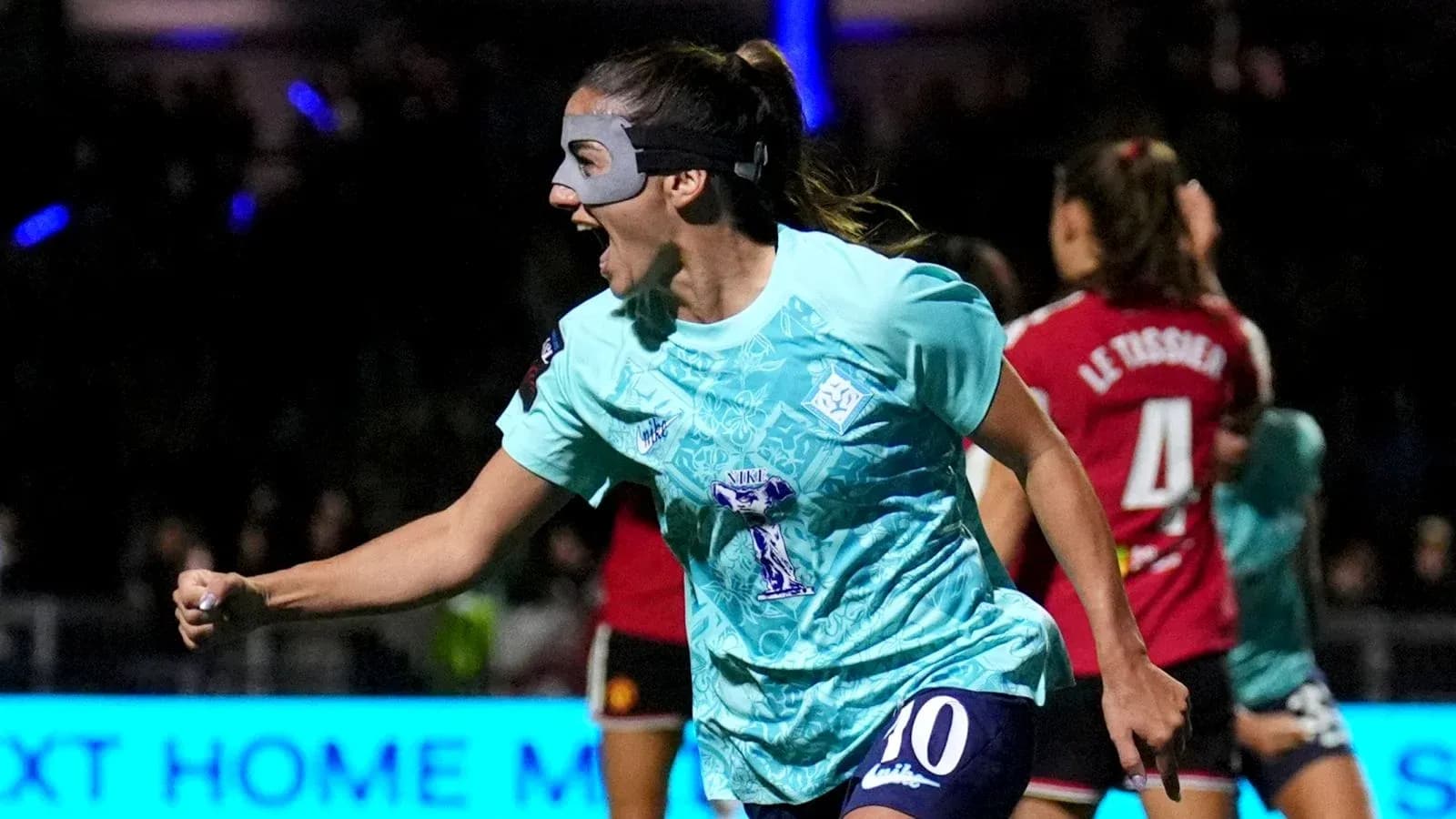 Jugadora celebrando un gol con una máscara facial