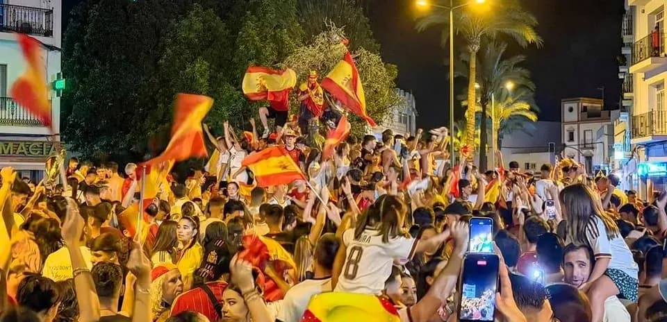 Multitud celebrando con banderas en la calle