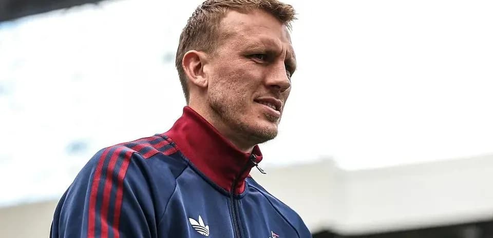 Jugador con chaqueta de entrenamiento en el estadio