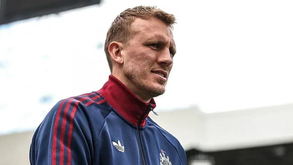 Jugador con chaqueta de entrenamiento en el estadio
