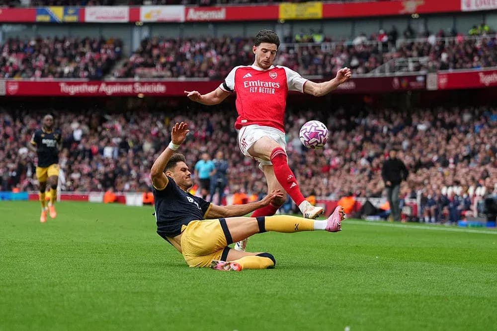 Jugador de Arsenal esquivando a oponente de West Ham