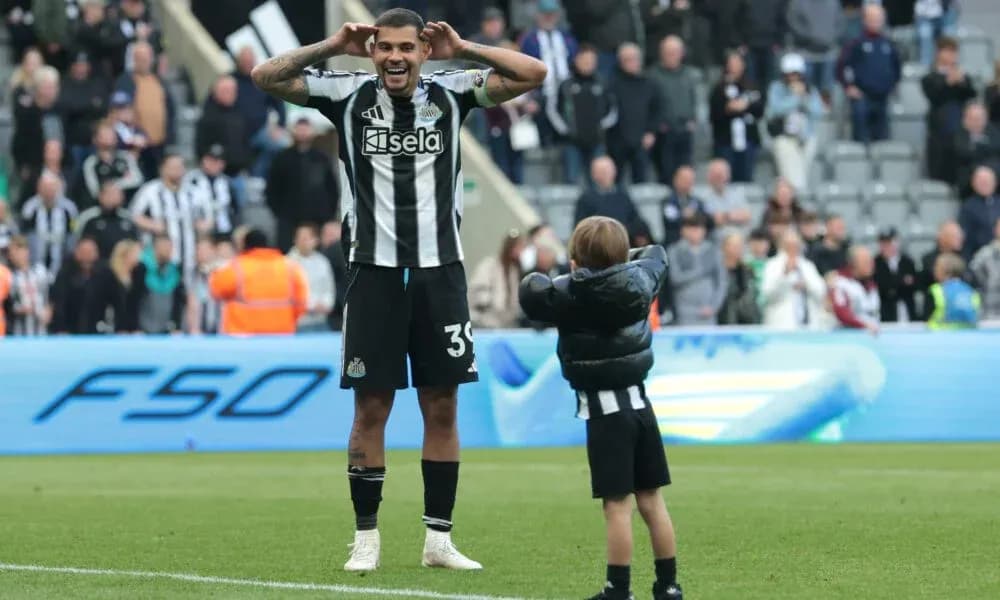 Jugador de Newcastle celebrando con un niño en el campo