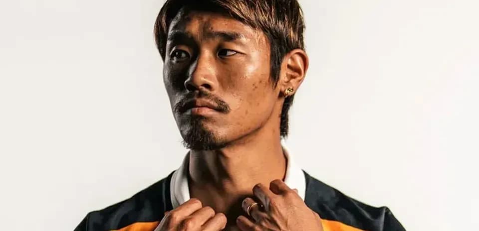 Jugador posando con camiseta deportiva en fondo claro