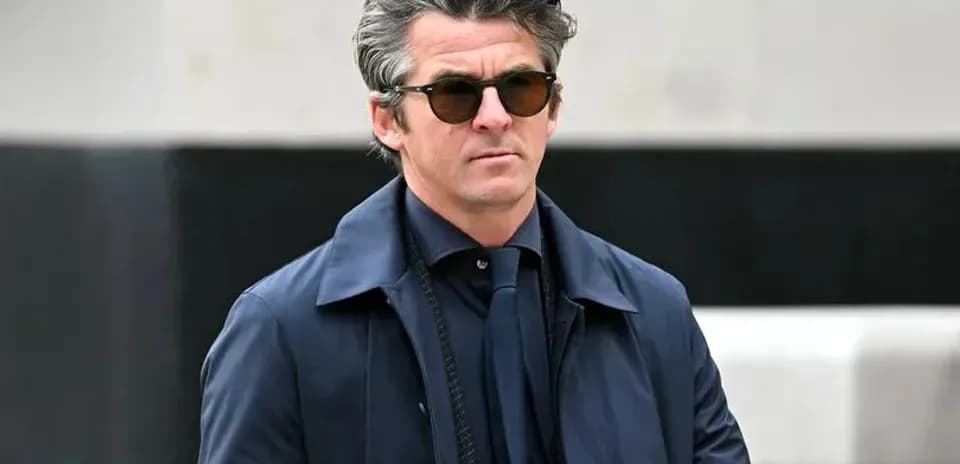 Hombre con gafas de sol caminando con abrigo oscuro