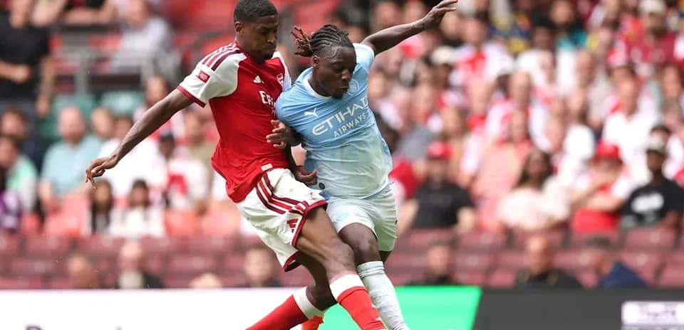 Jugadores de Arsenal y Manchester City luchando por el balón