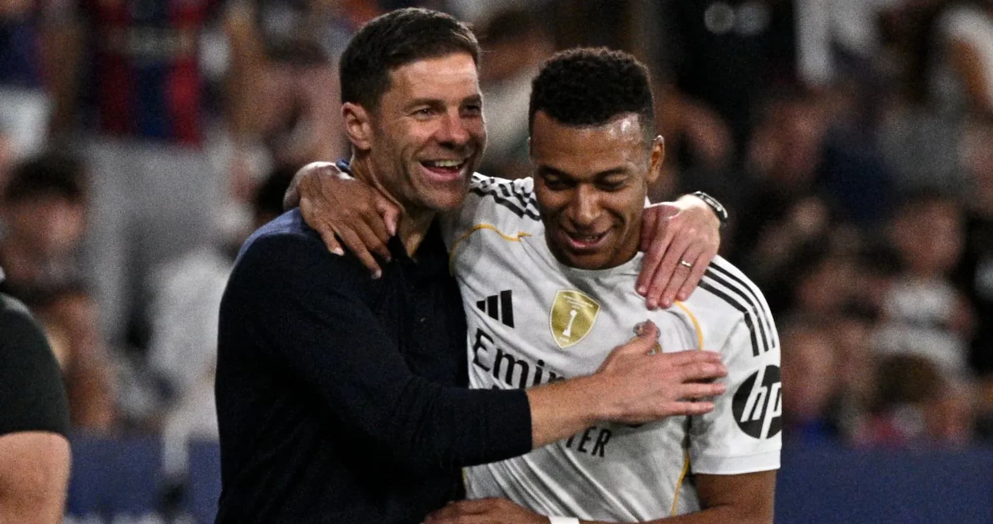 Entrenador y jugador abrazándose tras el partido