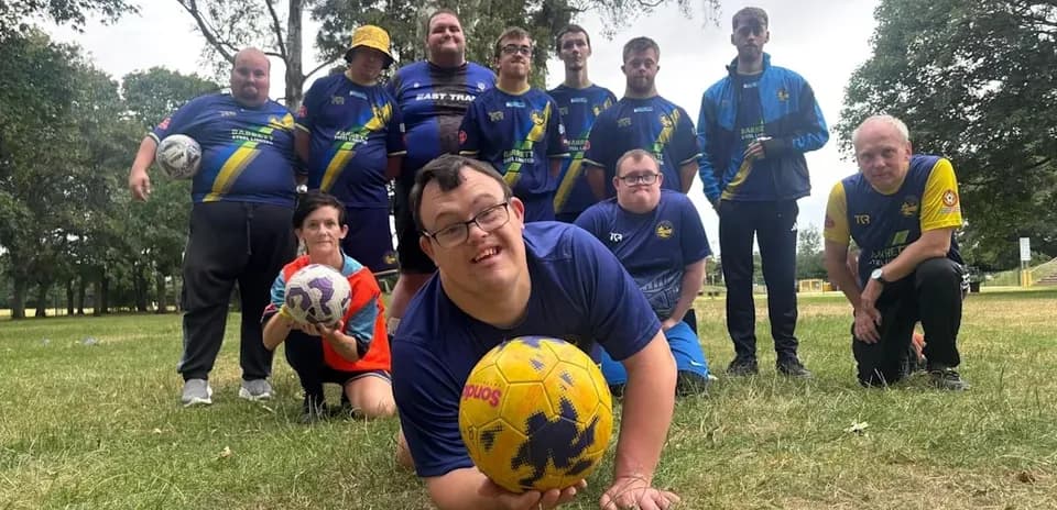 Equipo de fútbol posando en el parque con balones