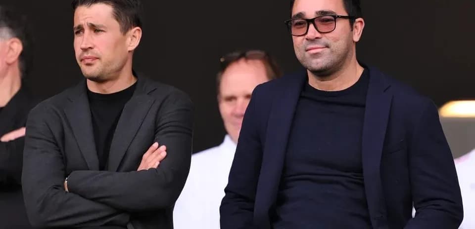Dos hombres sentados en un evento deportivo