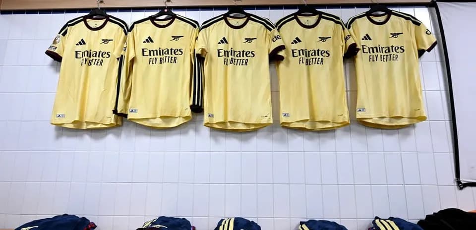 Camisetas amarillas colgadas en vestuario de equipo