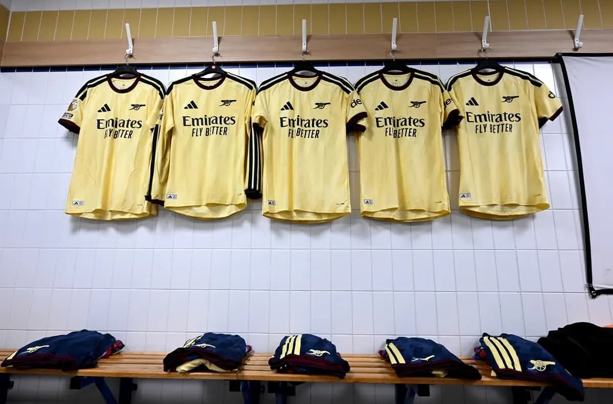 Camisetas amarillas colgadas en vestuario de equipo