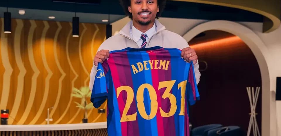 Jugador sosteniendo camiseta del FC Barcelona con nombre