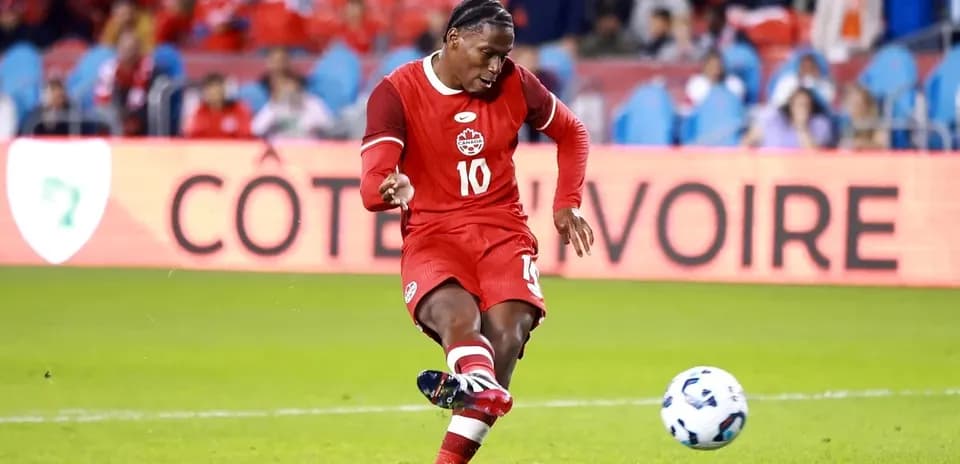 Jugador de Canadá pateando el balón en el campo