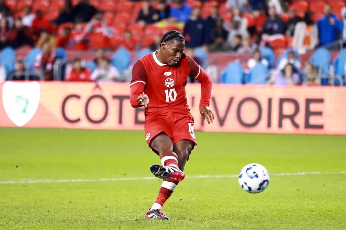 Jugador de Canadá pateando el balón en el campo
