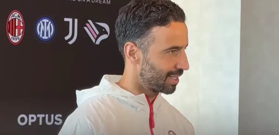 Persona hablando en conferencia de prensa con logos de clubes