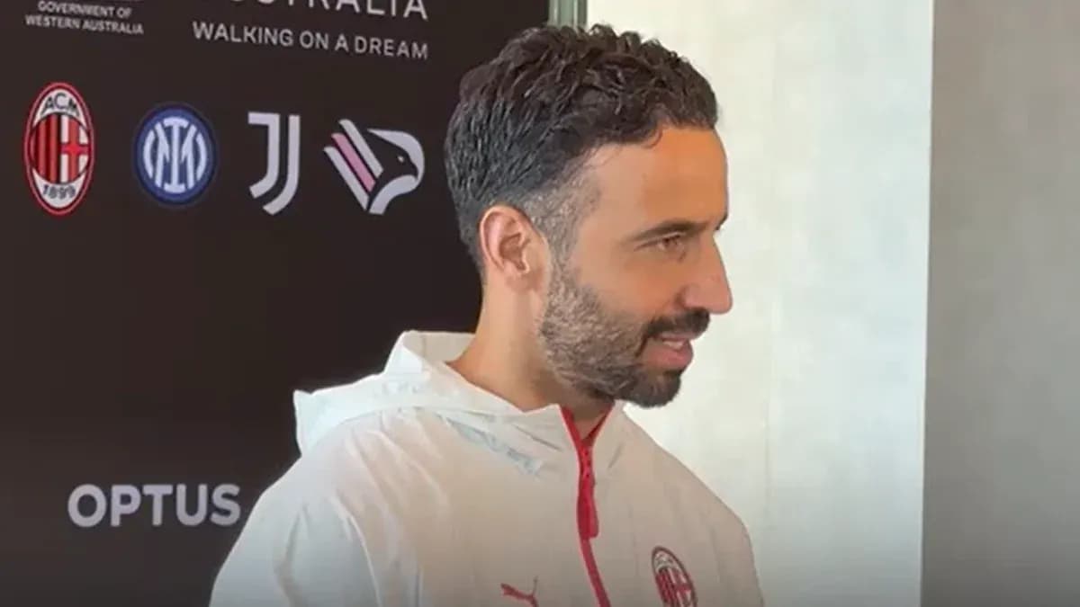 Persona hablando en conferencia de prensa con logos de clubes
