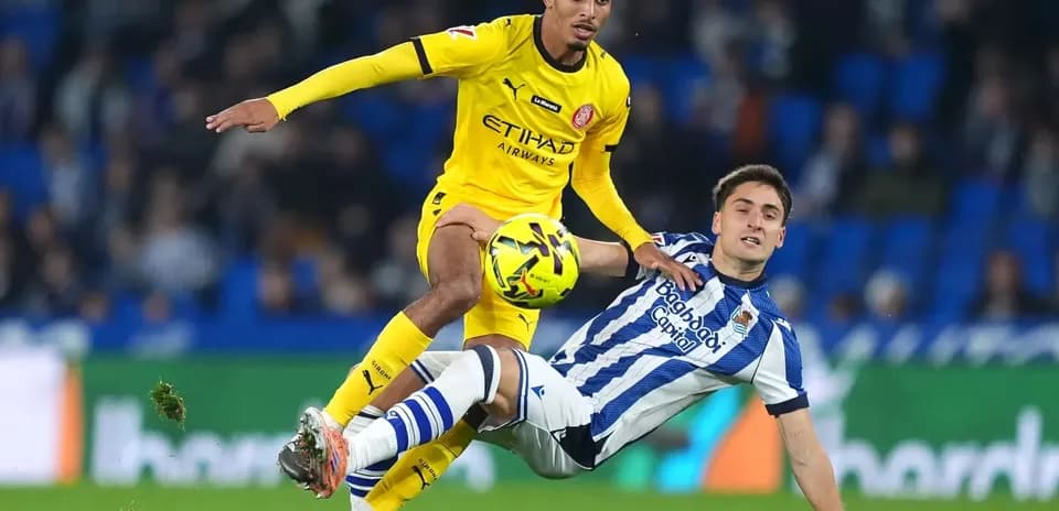 Jugador de Girona desafiando a un rival de la Real Sociedad