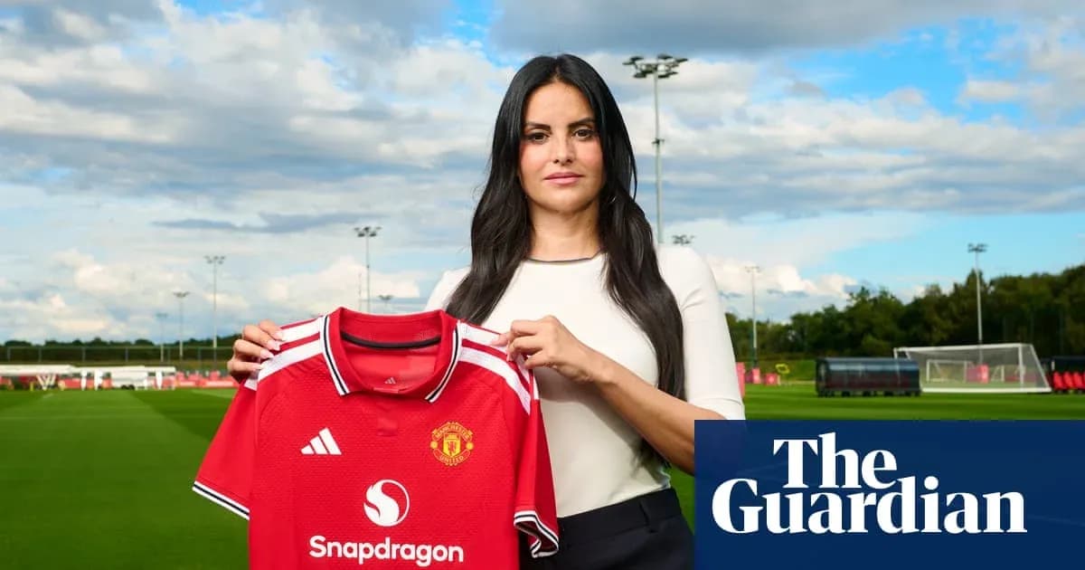 Mujer sosteniendo camiseta del Manchester United en campo