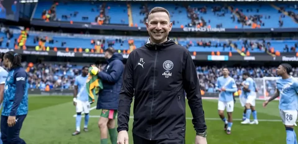Entrenador sonriente saliendo del campo tras el partido