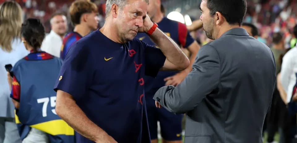 Entrenador conversando con asistente en el campo