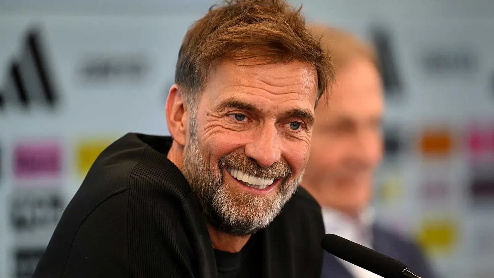 Entrenador sonriendo durante una conferencia de prensa