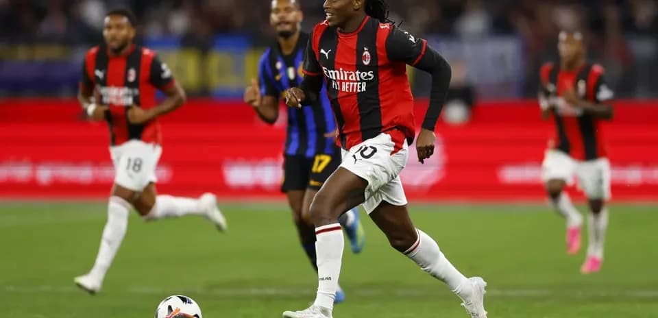 Jugador de AC Milan corriendo con el balón en campo