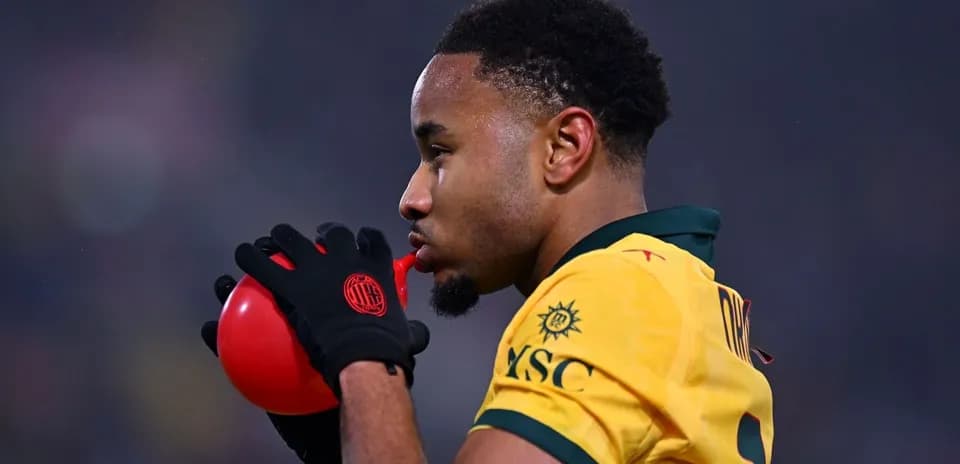 Jugador sosteniendo un balón rojo en el campo