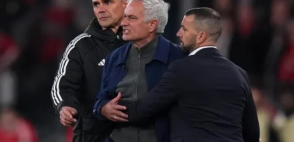 José Mourinho siendo contenido por asistentes en el campo