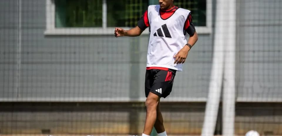 Jugador entrenando con balones en campo de fútbol